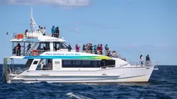Para wisatawan naik kapal pesiar untuk melihat paus di Teluk Jervis, Sydney selatan, Australia, pada 23 September 2020. (Xinhua/Bai Xuefei)
