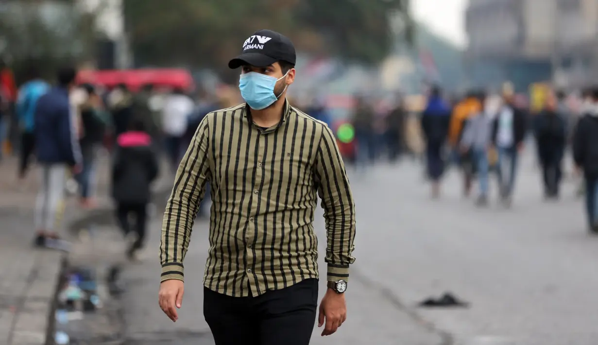 Seorang pria mengenakan masker di sebuah jalan di Baghdad, Irak, (25/2/2020). Irak mengumumkan empat kasus baru COVID-19 di Provinsi Kirkuk, wilayah utara, pada Selasa (25/2), sehingga total pasien terinfeksi di negara itu bertambah menjadi lima orang. (Xinhua/Khalil Dawood)