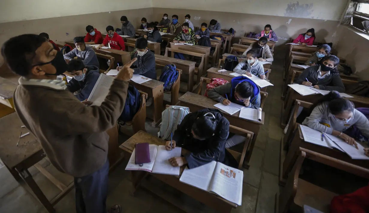 Suasana kegiatan belajar mengajar di kelas saat sekolah dibuka kembali setelah ditutup selama berbulan-bulan karena pandemi COVID-19 di Ahmedabad, India, Senin (11/1/2021). Negara bagian Gujarat telah membuka kembali sekolah hanya untuk kelas 10 dan 12. (AP Photo/Ajit Solanki)