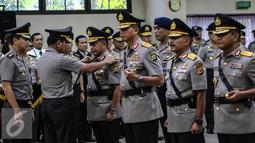 Kapolri Jend. (Pol.) Badrodin Haiti melepas tanda pangkat Kapolda Metro Jaya Irjen Tito Karnavian, saat sertijab Kapolda Metro Jaya di Rupatama, Mabes Polri, Jakarta, (21/3). Tito dipromosikan menjadi Kepala BNPT. (Liputan6.com/Fery Pradolo)