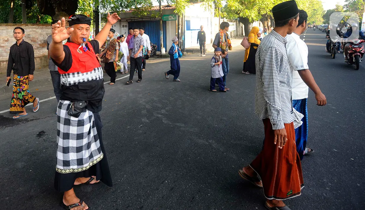 Pecalang turut mengatur lalu lintas di lokasi agar jalannya shalat tidak terganggu suara kendaraan. (merdeka.com/Arie Basuki)
