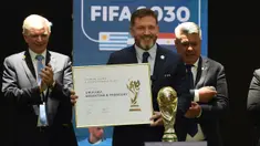 Presiden Paraguay, Alejandro Dominguez (tengah) memegang sertifikat yang mengesahkan Argentina, Paraguay, dan Uruguay sebagai negara tuan rumah Piala Dunia FIFA 2030 selama Kongres virtual FIFA di Luque, Paraguay pada 11 Desember 2024. (AFP/Daniel Duarte)