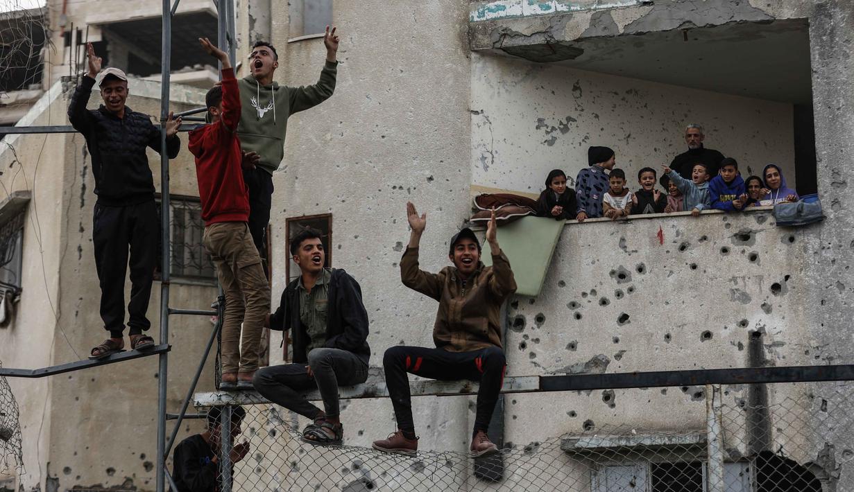 Di tengah kehancuran kota Gaza, peluit wasit, deru gelinding bola dan teriakan dari penonton seakan menjadi suara perlawanan yang terus menggelora. Tampak dalam foto, warga Palestina menyaksikan pertandingan sepak bola lima lawan lima di tengah reruntuhan bangunan yang hancur di Kota Gaza pada Senin 9 Februari 2026. (Omar AL-QATTAA/AFP)