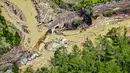 Pemerintah Kabupaten Bener Meriah telah mengumumkan status darurat bencana untuk memobilisasi bantuan dan upaya pemulihan. Tampak dalam foto, sebuah jembatan yang rusak akibat banjir bandang terlihat di Kabupaten Bener Meriah, Provinsi Aceh, pada Kamis 4 Desember 2025. (CHAIDEER MAHYUDDIN/AFP)
