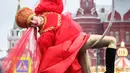 Seorang seniman jalanan tampil di jalan Tverskaya di depan Kremlin saat meramaikan sebuah festival yang menandai Tahun Baru dan Natal di Moskow, Rusia (2/1). Jalan-jalan di Rusia dipenuhi seniman jelang perayaan Natal Orthodox. (AFP Photo/Yuri Kadobnov)