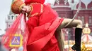 Seorang seniman jalanan tampil di jalan Tverskaya di depan Kremlin saat meramaikan sebuah festival yang menandai Tahun Baru dan Natal di Moskow, Rusia (2/1). Jalan-jalan di Rusia dipenuhi seniman jelang perayaan Natal Orthodox. (AFP Photo/Yuri Kadobnov)