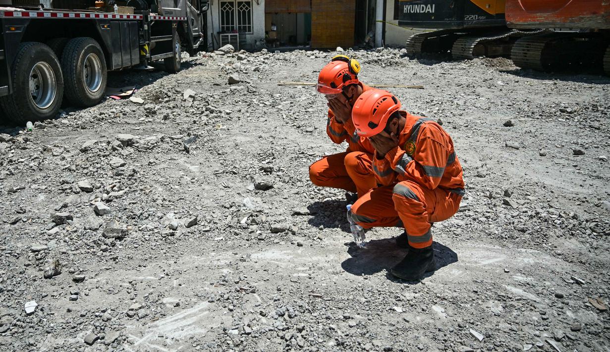 Personel dari tim dari Badan Nasional Pencarian dan Pertolongan (BASARNAS) berdoa setelah prosesi penutupan yang menandai berakhirnya operasi pencarian dan penyelamatan korban runtuhnya bangunan musala di Pondok Pesantren Al Khoziny di Sidoarjo, Jawa Timur, pada 7 Oktober 2025. (JUNI KRISWANTO/AFP)