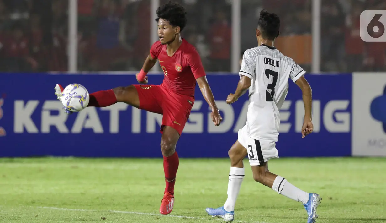Pemain Timnas Indonesia U-19, Amiruddin Bagus Alfikri (kiri) berebut bola dengan pemain Timor Leste, Orcelio Nobelito Moises pada laga kualifikasi Grup K Piala AFC U-19 2020 di Stadion Madya Gelora Bung Karno, Jakarta, Rabu (6/11/2019). Indonesia unggul 3-1. (Liputan6.com/Helmi Fithriansyah)