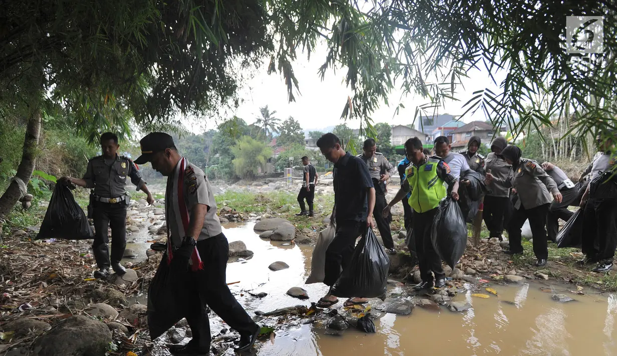 Anggota Polantas Polres Bogor membawa kantung berisi sampah di kawasan aliran Sungai Ciliwung, gadog, Bogor (20/9). Kegiatan ini dilakukan Sat Lantas Polres Bogor bersama komunitas pecinta alam dan warga sekitar. (Merdeka.com/Arie Basuki)