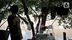 Salah seorang warga berdiri di pinggir bantaran kali usai banjir merendam gubuk miliknya yang berada di pinggir Kanal Banjir Barat (KBB), Jakarta, Rabu (8/1/2020). (merdeka.com/Iqbal S Nugroho)