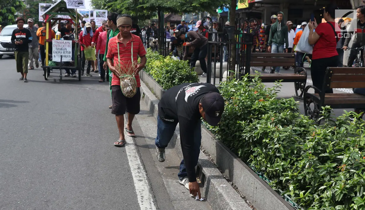 Kelompok pengemudi becak motor bersama aktivis melakukan aksi berjalan kaki sambil memunguti sampah menuju titik Nol kilometer Yogyakarta, Senin (22/4). Aksi memperingati Hari Bumi ini mengajak masyakarat untuk mengurangi sampah dan penggunaan plastik. (Liputan6.com/Helmi Fithriansyah)