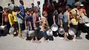 Anak-anak Palestina mengantre untuk menerima makanan panas dari dapur amal kamp pengungsi Nuseirat di Jalur Gaza yang dikepung Israel pada 11 September 2025. (Eyad BABA/AFP)