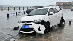 Sebuah mobil rusak setelah dihantam ombak yang disebabkan Topan Yagi di sepanjang pantai laut di Qingdao di provinsi Shandong timur China (13/8). Lebih dari 200.000 warga mengungsi saat topan mencapai daratan pantai timur. (AFP Photo)
