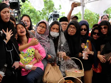 Zanette Kalila Azaira (13) menangis histeris saat prosesi pemakaman jenazah korban pembunuhan Pulomas di TPU Tanah Kusir, Jakarta, Rabu (28/12). Belum diketahui motif peristiwa tersebut, apakah perampokan atau pembunuhan. (Liputan6.com/Gempur M Surya)