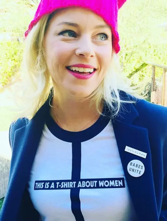 Elizabeth Banks mengenakan kaos bertuliskan "This is a T-Shirt About Woman" yang dipadukan dengan blazer biru dan kupluk pink (instagram/elizabethbanks)