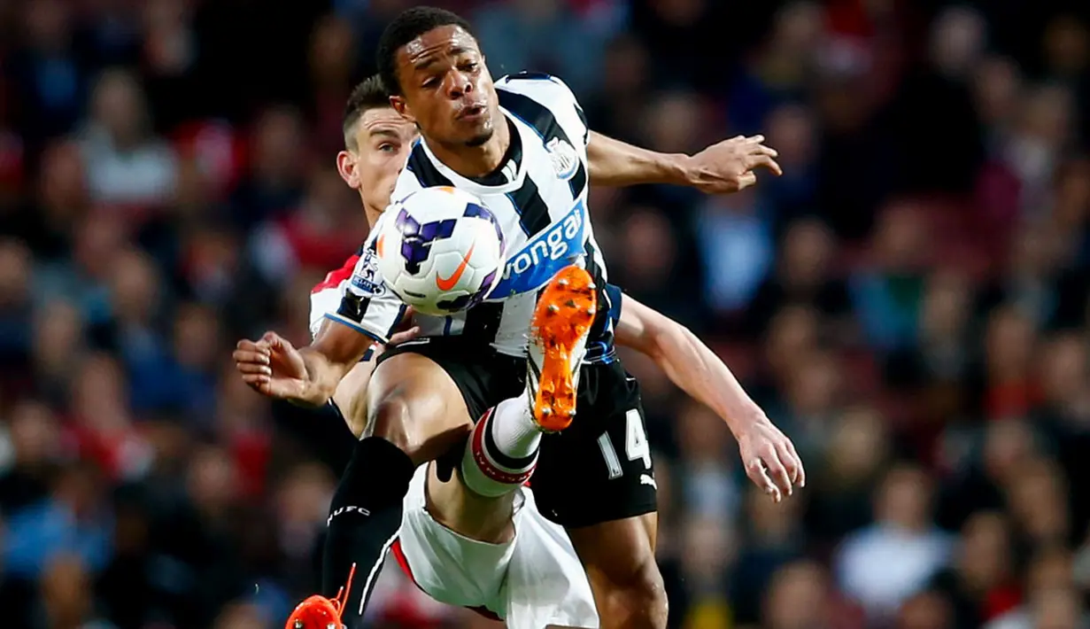 Pemain belakang Arsenal, Laurent Koscielny (belakang) berusaha merebut bola dari Loic Remy (Newcastle United) saat berlaga di Liga Primer Inggris di Stadion Emirates, London (28/4/2014). (REUTERS/Eddie Keogh)