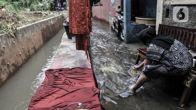 Warga mencuci pakaian saat banjir merendam permukiman warga di kawasan Kemang Timur XI, Jakarta Selatan, Minggu (21/2/2021). Ketinggian air mencapai sepinggang orang dewasa. (merdeka.com/Iqbal S. Nugroho)