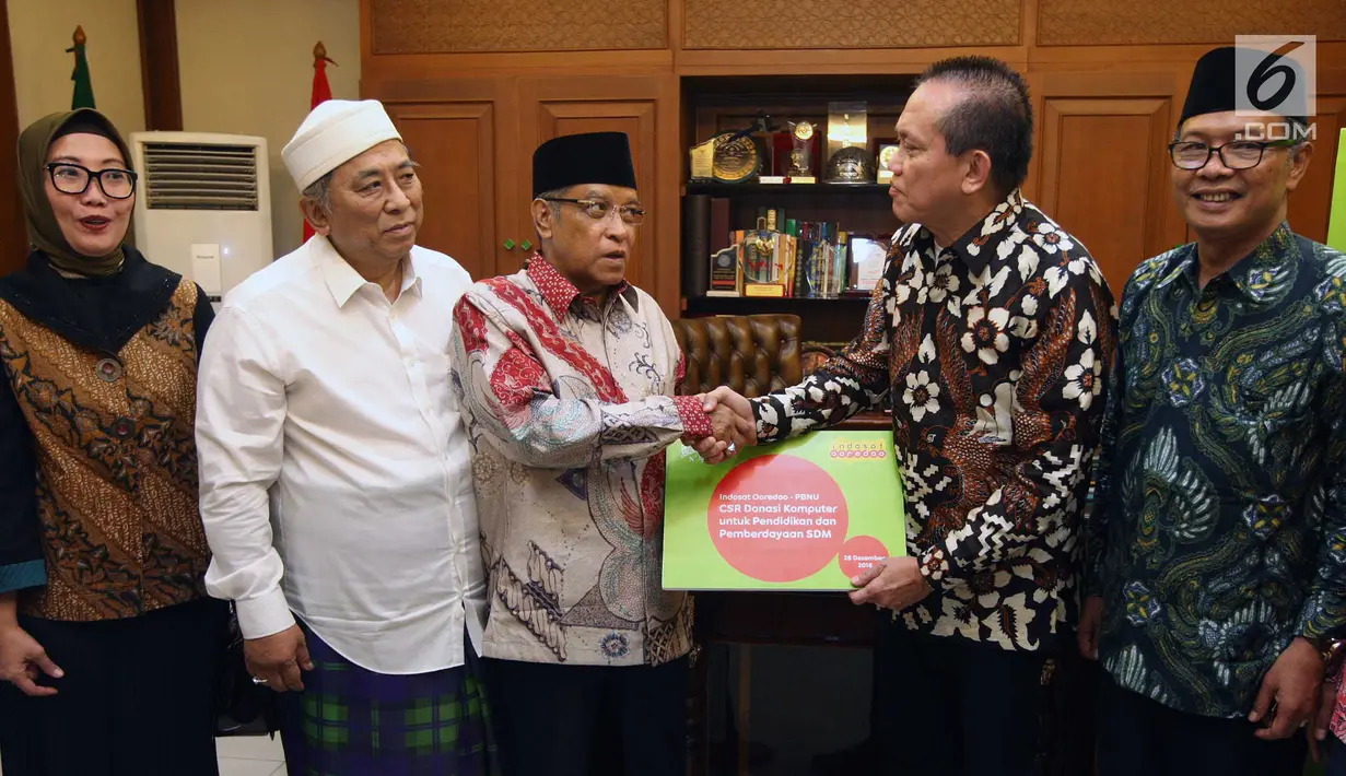 President Director & CEO Indosat Ooredoo Chris Kanter secara simbolis menyerahkan donasi komputer kepada Ketua Umum Pengurus Besar Nahdlatul Ulama (PBNU) KH Said Aqil Siroj di Kantor Pusat PBNU, Jakarta, Jumat (28/12). (Liputan6.com/HO/Eko)