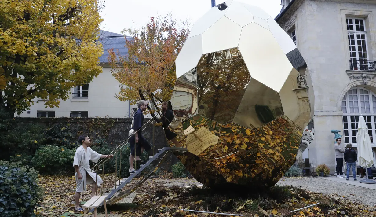 Pengunjung masuk ke dalam Solar Egg, fasilitas sauna berbentuk telur raksasa, di Institut Swedia di Paris, Rabu (15/11). Sauna itu bisa menampung hingga delapan orang dan dipanaskan melalui semacam tungku kayu berbentuk hati. (PATRICK KOVARIK / AFP)