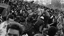 Para suporter coba menyelamatkan diri dari tembok ambruk di Stadion Heysel, Brussels Belgiapada tanggal 29 Mei 1985 saat laga final Liverpool vs Juventus. . (AP Photo/Gianni Foggia, File)