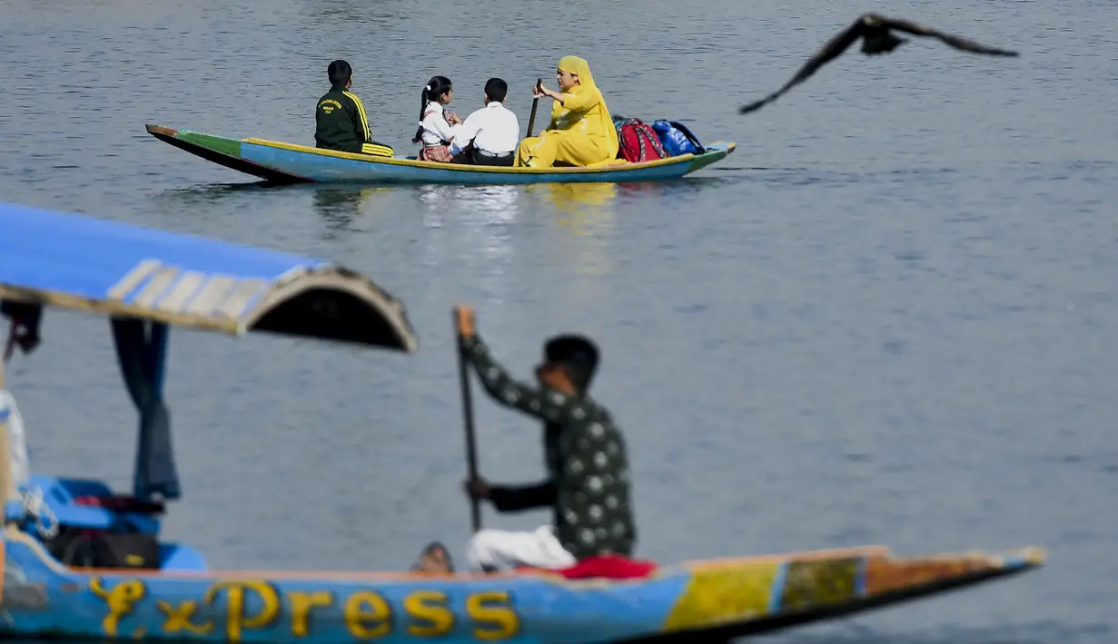 <p>Seorang perempuan (atas) mendayung perahu selama jam sekolah di Danau Dal di Srinagar, India, Rabu (11/5/2022). Danau terbesar di negara bagian tersebut penting untuk kegiatan perikanan, perairan, rekreasi, dan pariwisata. (TAUSEEF MUSTAFA / AFP)</p>