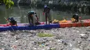 Selain mengangkat sampah, relawan juga memilah jenis limbah yang terbawa arus sungai. Tampak dalam foto, aktivis dari Ecoton (Ecological Observation and Wetlands Conservation) bersama pekerja dari Dinas Lingkungan Hidup Pemerintah Kota Surabaya, Jawa Timur, membersihkan sampah dari Sungai Kali Tebu, pada Senin 11 Mei 2026. (JUNI KRISWANTO/AFP)