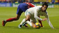 Gelandang Real Madrid, Isco, terjatuh saat pertandingan melawan Atletico Madrid pada laga La Liga di Stadion Metropolitano, Sabtu (18/11/2017). Derbi Madrid tersebut berakhir dengan skor 0-0. (AP/Paul White)