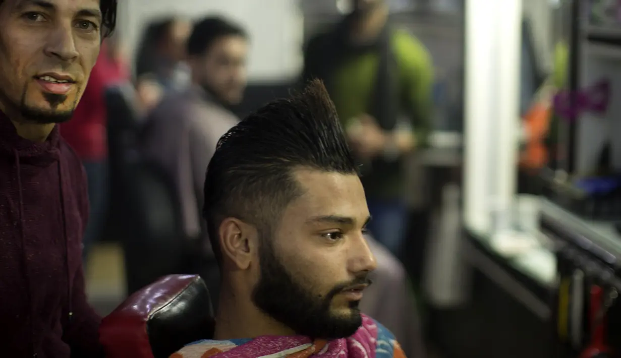 Seorang pelanggan setelah memotong rambutnya di sebuah barbershop milik pria Palestina, Ramadan Edwan, di kamp pengungsian Rafah, di selatan Jalur Gaza, Rabu (1/2). Ramadan Edwan menggunakan api untuk mencukur rambut pelanggannya. (MAHMUD HAMS/AFP)