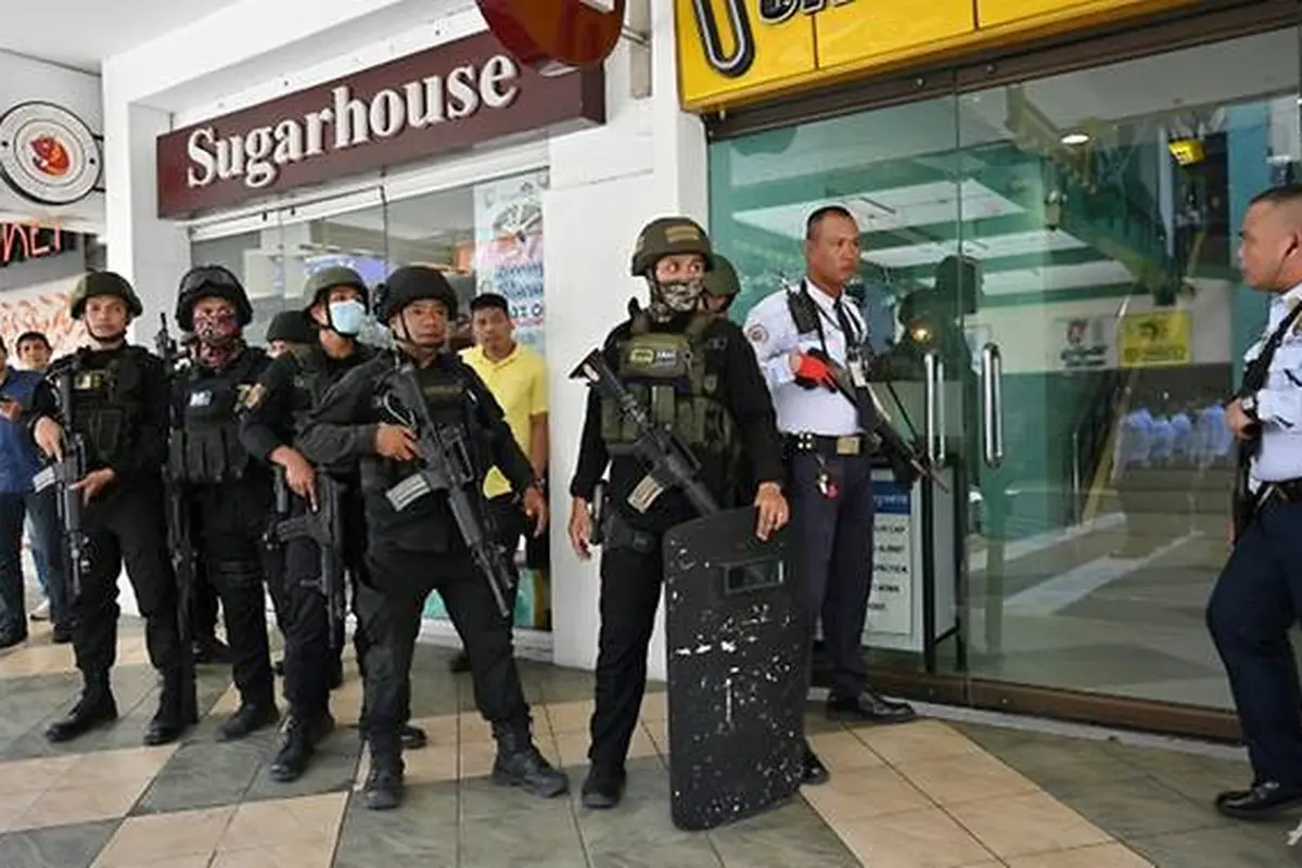Walikota bagian Manila mengatakan kepada wartawan bahwa seorang penjaga keamanan menahan hingga 30 orang di kantor administrasi dan telah menembak setidaknya satu orang.