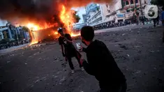 Seorang pria berfoto di depan pos polisi yang terbakar di kawasan Harmoni, Jakarta, Kamis (8/10/2020). Bentrokan pecah saat massa yang hendak menuju Istana Negara untuk menggelar unjuk rasa menolak UU Cipta Kerja diadang oleh aparat kepolisian. (Liputan6.com/Faizal Fanani)