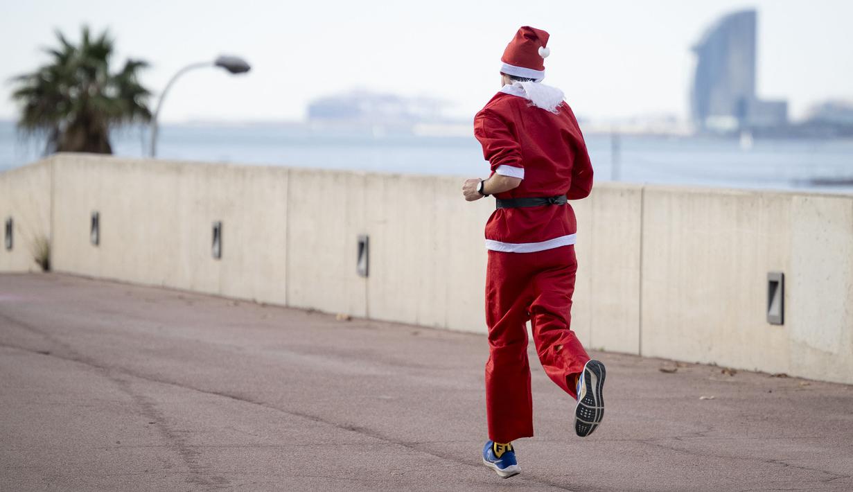 Seorang pelari berkompetisi dalam acara fun run 5 km yang berlangsung di Barcelona, Spanyol pada Minggu (22/12/2024) waktu setempat. Acara tersebut menjadi salah satu bentuk menyambut hari Natal. (AFP/Josep Lago)