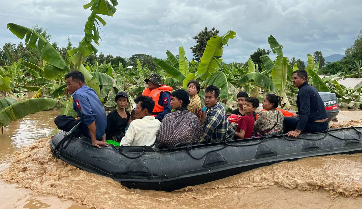 Beberapa penduduk desa terpaksa menggunakan rakit darurat menyelamatkan diri serta membawa harta benda yang masih bisa dibawa. (Sai Aung MAIN/AFP)