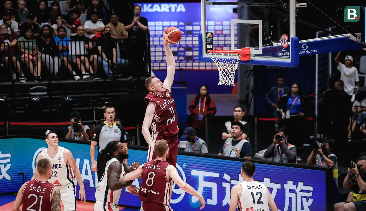 Pebasket Latvia, Rolands Smits melakukan slam dunk saat laga kedua Grup H Piala Dunia FIBA 2023 melawan Prancis di Indonesia Arena, Senayan, Jakarta, Minggu (27/08/2023). (Bola.com/Bagaskara Lazuardi)