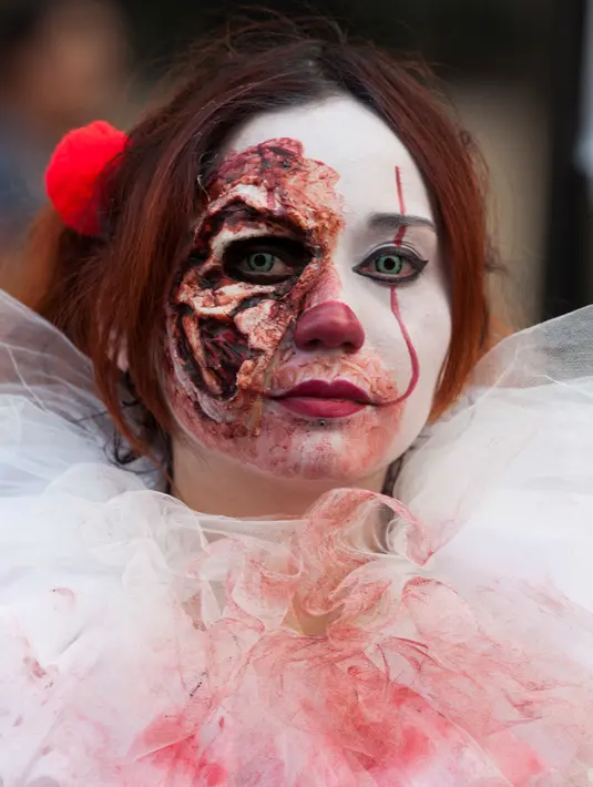 Seorang wanita berpartisipasi dalam Zombie Walk di Mexico City, Minggu (11/11). Dalam acara tahunan itu ratusan orang dengan penampilan yang seram serta mengenakan pakaian compang-camping berkumpul di pusat bersejarah ibu kota Meksiko. (AP/Claudio Cruz)