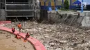 Petugas Dinas Lingkungan Hidup Pemprov DKI saat membersihkan sampah yang memenuhi sekitar Pintu Air Manggarai, Jakarta, Minggu (8/4). Menurut petugas, sebanyak 312 meter kubik sampah memenuhi pintu air. (Merdeka.com/Iqbal Nugroho)