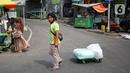 Seorang porter membawa pakaian jadi yang di kemas di karung di Kawasan Tanah Abang, Jakarta, Senin (11/10/2021). Menurunnya level PPKM jakarta menjadi level 3 membawa berkah bagi para kuli panggung dikarenakan geliat pasar tersebut kembali berjalan. (Liputan6.com/Angga Yuniar)