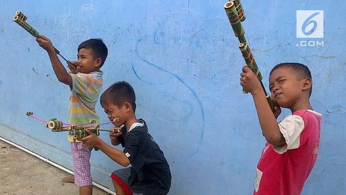 Anak-anak bermain pistol bambu, sebuah permainan yang kini digantikan paint ball yang butuh arena khusus dan waktu khusus serta berbiaya tinggi. (foto: Liputan6.com / felek wahyu)