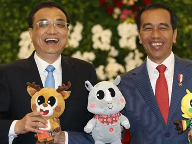 Presiden Joko Widodo memegang boneka maskot Asian Games 2018 saat berfoto bersama dengan Perdana Menteri China Li Keqiang di Istana Bogor (7/5). Pertemuan itu untuk menyepakati dua poin kerjasama. (AFP/Pool/Dita Alangkara)