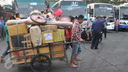Dua orang pria sedang menarik gerobak berisi barang penumpang di terminal Pulogadung, Jakarta, Jumat (10/7/15). Terminal Polugadung memberangkatkan sebanyak 521 penumpang dan bus yang diberangkatkan sekitar 118 bus. (Liputan6.com/Herman Zakharia)