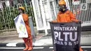 Sejumlah aktivis Walhi menggelar aksi di depan Gedung ESDM, Jakarta, Jumat (11/12/2020). Dalam aksinya, mereka menuntut agar pemerintah menghentikan pembangunan PLTU Jawa 9 dan 10 serta beralih ke energi terbarukan karena alasan lingkungan. (Liputan6.com/Faizal Fanani)