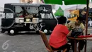 Pengunjung menunggu pesanan makanan yang dijual di atas mobil van di area Food Truck Convoy dalam ajang Indonesia International Motor Show (IIMS) 2015 di JIExpo Kemayoran, Jakarta, Selasa (25/08/2015). (Liputan6.com/Andrian M Tunay)