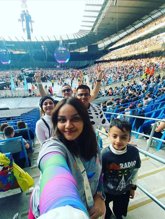 Untuk menyaksikan konser Chris Martin dan kawan-kawan, presenter kondang berusia 50 tahun itu menuju Manchaster. Potret Ferdy bersama istri dan anak-anaknya di dalam stadion tempat konser berlangsung. [Instagram/ferdyhasan]