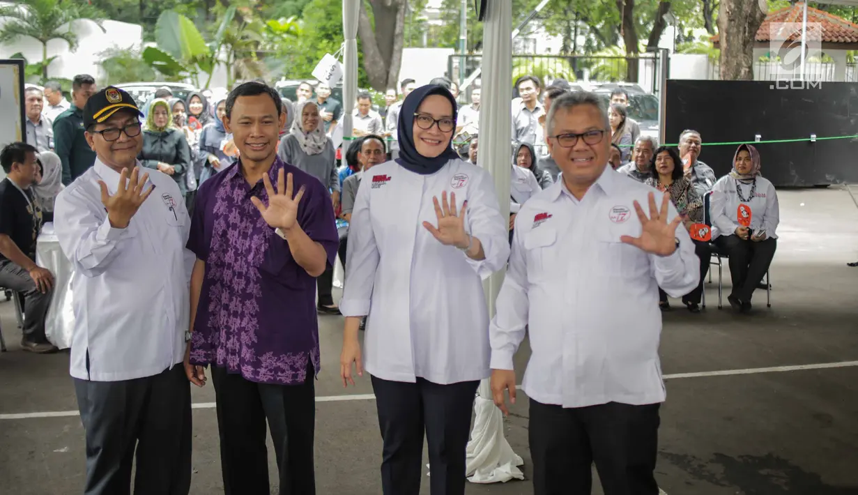 Ketua KPU Arief Budiman (kanan) bersama Komisioner KPU menunjukkan jari bertinta usai mencoblos dalam simulasi pemungutan dan penghitungan suara Pemilu 2019 di halaman Gedung KPU, Jakarta, Selasa (12/3). (Liputan6.com/Faizal Fanani)