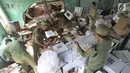 Petugas Linmas menyelamatkan kotak suara kardus yang sebagian rusak terendam banjir di gudang tempat penyimpanan logistik di Kecamatan Ciseeng, Bogor, Senin (15/4). Lebih dari 600 kotak suara rusak akibat tembok gudang jebol diterpa hujan lebat dan angin kencang semalam. (merdeka.com/Arie Basuki)