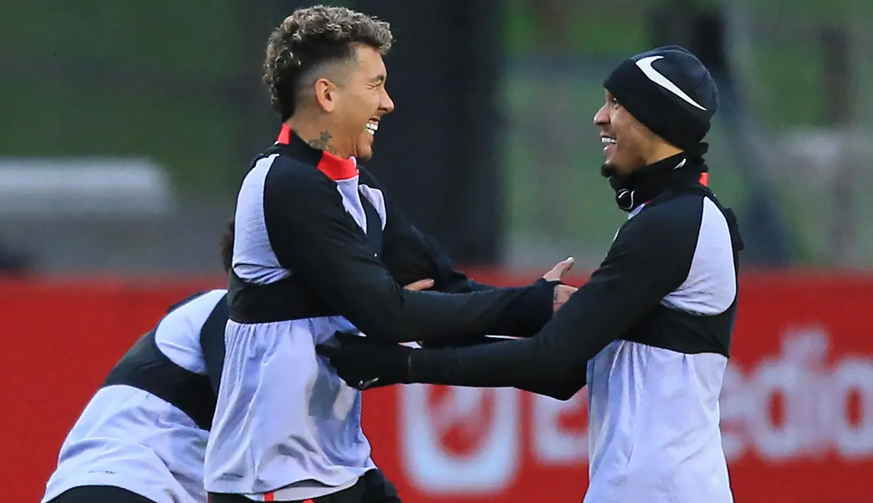 Pemain Liverpool Roberto Firmino (kiri) bercanda dengan Fabinho (kanan) saat sesi latihan tim di Pusat Pelatihan AXA, Liverpool, Inggris, 20 Februari 2023. Liverpool akan menghadapi pertandingan sepak bola leg pertama babak 16 besar Liga Champions UEFA melawan Real Madrid. (Lindsey Parnaby/AFP)