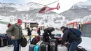 Sejumlah turis merapihkan koper bawaannya setelah dievakuasi dari ski Zermatt di  Taesch, Pegunungan Alpen Swiss (10/1). Bencana tersebut menyebabkan terputusnya jalur kereta api dan seluruh akses menuju Zermatt. (AFP Photo/Fabrice Coffrini)