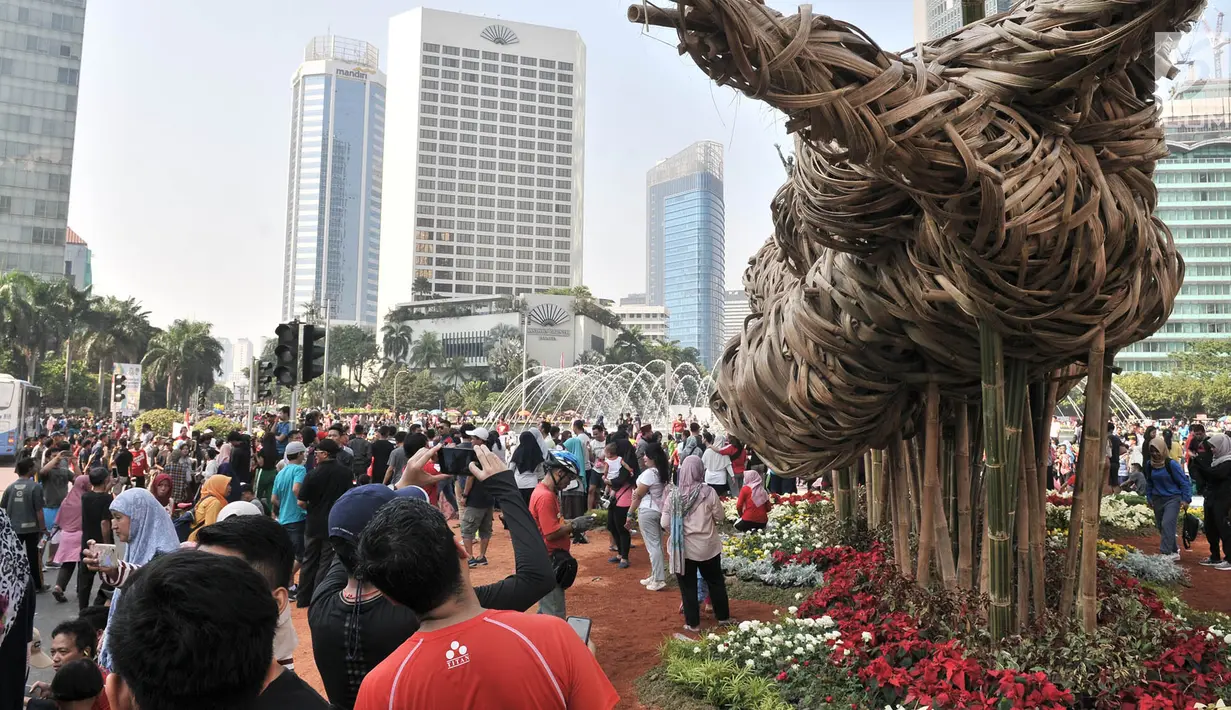Instalasi bambu "Getih Getah" di Bundaran HI menjadi daya tarik pengunjung car free day, Jakarta, Minggu (19/8). Mereka beramai-ramai berswafoto di depan instalasi bambu yang dibuat menyambut Asian Games 2018 tersebut. (Merdeka.com/ Iqbal S. Nugroho)