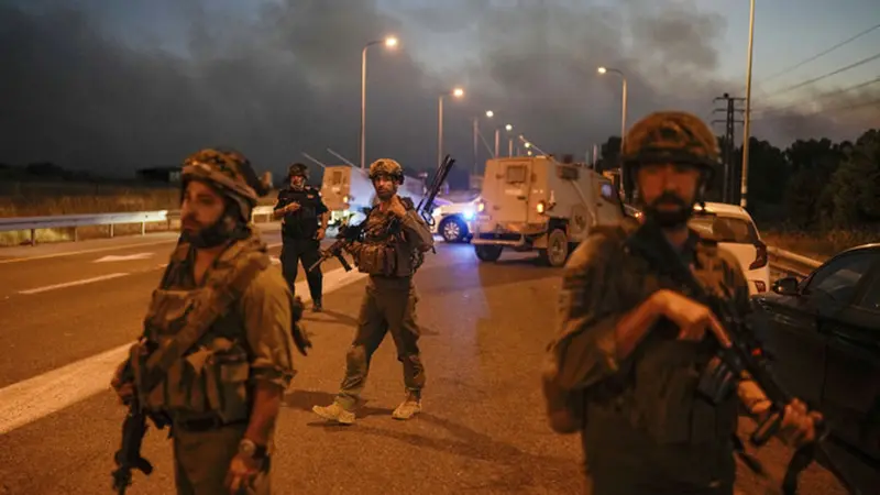 Tentara Israel memblokir jalan dengan latar belakang asap kebakaran setelah roket bombardir Hizbullah Lebanon menghantam Dataran Tinggi Golan yang dianeksasi Israel, Selasa, 9 Juli 2024. (AP)
