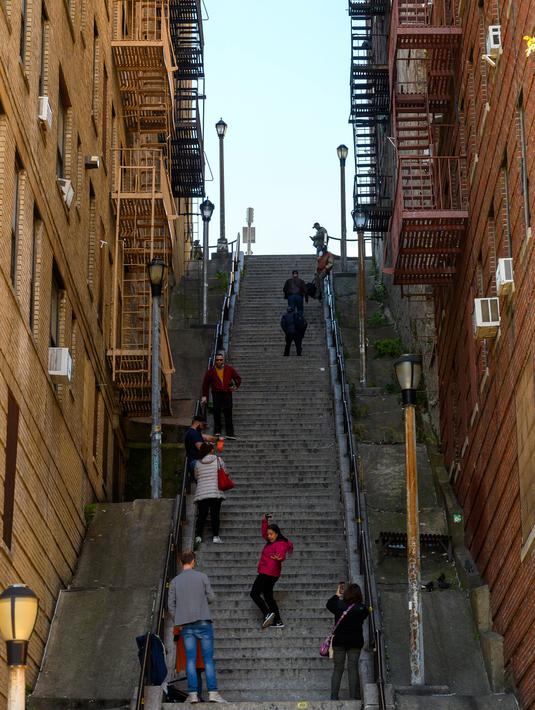 Pengunjung memadati tangga di kawasan Bronx, New York, 23 Oktober 2019. Sejumlah orang mulai mendatangi lokasi tangga yang sudah diberi label Joker Stairs tersebut untuk berfoto meniru adegan ikonik di Film Joker. (Don Emmert / AFP)