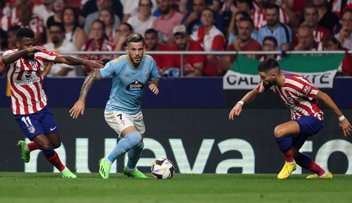Pemain Atletico Madrid Thomas Lemar (kiri) berebut bola dengan pemain Celta Vigo Carles Perez (tengah) pada pertandingan sepak bola Liga Spanyol di Stadion Wanda Metropolitano, Madrid, Spanyol, 10 September 2022. Atletico Madrid menang 4-1. (Thomas COEX/AFP)